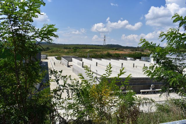 Platforme și compartimente de beton ale instalației de tratare, parțial acoperite de vegetație